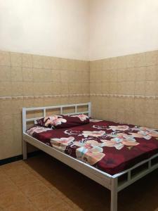 1 dormitorio con 1 cama con manta roja en Griya Erlangga, en Kediri