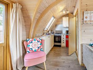 a small kitchen with a pink chair in a tiny house at 2 Bed in Sheinton 93397 in Leighton