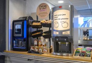une machine à café assise sur un comptoir dans un magasin dans l'établissement B&B HOTEL Nîmes Centre Arènes, à Nîmes