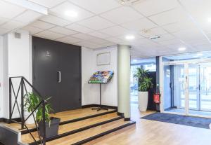 an office lobby with stairs and a black door at B&B HOTEL Nîmes Centre Arènes in Nîmes