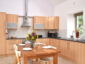 a kitchen with a wooden table with flowers on it at 2 Bed in Blackdown Hills AONB 93402 in Luppitt
