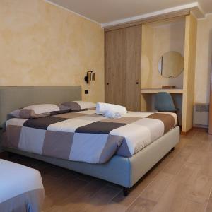 Habitación de hotel con 2 camas y espejo en Albergo Ristorante Da Elia en SantʼOmobono Imagna