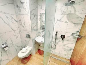 a bathroom with a shower and a toilet and a sink at Arboro Borovets Gardens E50 in Borovets