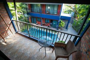 een balkon met een tafel en stoelen en een gebouw bij KRAAM Silhouette Hotel and Cafe Phuket in Chalong 