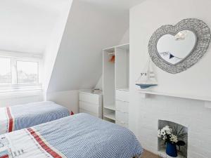 biała sypialnia z 2 łóżkami i lustrem. w obiekcie 3 Bed in Sutton on Sea SEALC w mieście Sutton on Sea