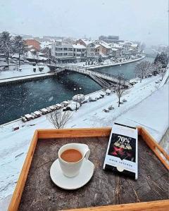 a cup of coffee sitting on a table with a book at Struga Riverview Hotel in Struga