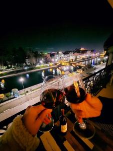 two people holding glasses of wine on a table at Struga Riverview Hotel in Struga
