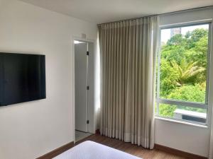 Pokój z dużym oknem i telewizorem w obiekcie Penthouse with private pool & amazing views w mieście Salvador
