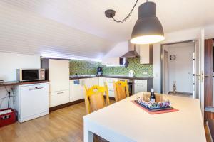 a kitchen with white cabinets and a table with chairs at Lydias Ferienwohnung in Schmallenberg