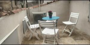 un tavolo e 4 sedie su un balcone con tavolo e sedie di La Montille a Arles Altre 6 foto