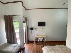 a bedroom with a desk and a tv on the wall at EMWEKA Residence Balikpapan in Balikpapan