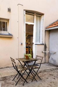 une table et deux chaises devant un bâtiment dans l'établissement Le Perchoir de Niro, à Nantes