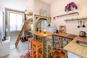 uma cozinha com uma mesa de madeira e uma cozinha com uma escada em Le Perchoir de Niro em Nantes