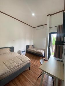 a bedroom with a bed and a table and a tv at EMWEKA Residence Balikpapan in Balikpapan