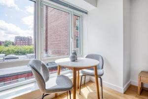 two chairs and a table in a room with a window at Back Bay Studio w Gym nr Newbury St BOS-459 in Boston