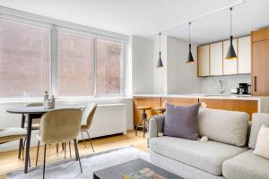 a living room with a couch and a table at Midtown E 2br w elevator doorman gym nr UN NYC-752 in New York