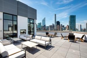 a rooftop patio with furniture and a view of the city at Midtown E 2br w elevator doorman gym nr UN NYC-752 in New York