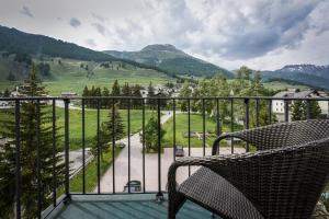a balcony with a chair and a view of a valley at Cresta Palace Celerina in Celerina