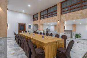 een grote vergaderzaal met een lange tafel en stoelen bij Hotel Apex in Surat