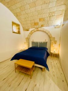 um quarto com uma cama azul e uma mesa em La Bitta Suite em Brindisi