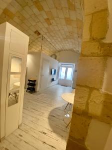 um quarto com uma mesa e um tecto de pedra em La Bitta Suite em Brindisi
