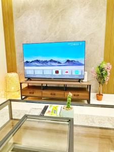 un televisor sentado en una mesa en una sala de estar en شقة بغرفتين نوم وبلكونة خاصة ١٥ en Riad