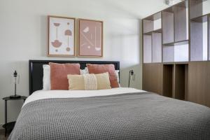1 dormitorio con 1 cama grande con almohadas rosas en Blueground First Hill gym nr green spaces SEA-707, en Seattle