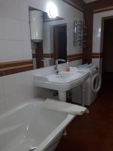 ein Badezimmer mit zwei Waschbecken, einer Badewanne und einem Spiegel in der Unterkunft Апартаменти 100 кв.м на Шота Руставелі in Odessa