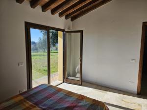 a bedroom with a bed and a sliding glass door at Casa Regina in Val di Pugna