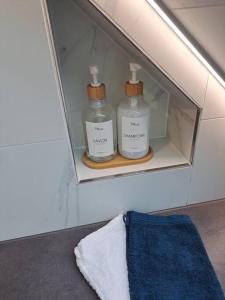 two bottles of soap in a shelf in a bathroom at Bel Appartement, Sélestat in Sélestat