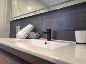 umywalkę z ręcznikiem i kranem w łazience w obiekcie Bel Appartement, Sélestat w mieście Sélestat