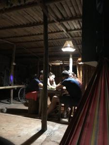 een groep mensen die aan een tafel zitten bij Happy Homestay Banlung & Trekking in Banlung