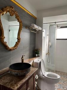 Quinstel Hostel في بانكوك: حمام مع حوض ومرحاض ومرآة