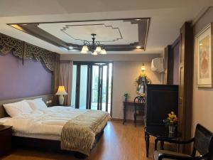 a bedroom with a large bed and a chandelier at Quinstel Hostel in Bangkok
