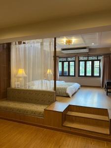a large bedroom with two beds and a large window at Quinstel Hostel in Bangkok