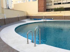 トレモリノスにあるApartamento con piscinaの建物内のスイミングプール(金属製の手すり付)