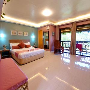a large bedroom with a bed and a balcony at Samkara Restaurant and Garden Resort in Majayjay