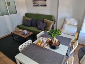 トレモリノスにあるApartamento con piscinaのリビングルーム(テーブル、緑のソファ付)