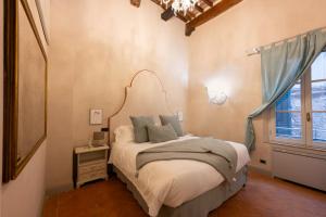 - une chambre avec un lit et une grande fenêtre dans l'établissement Tuscan Palace - Avignonesi apartment, à Montepulciano