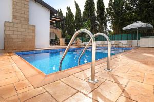 een zwembad met metalen leuningen in een tuin bij Villa Anthia - 2bed with Large Pool in Ayia Napa