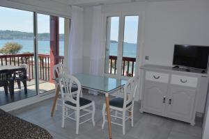 ein Esszimmer mit einem Tisch und Stühlen sowie einem Balkon in der Unterkunft Résidence ITXASOA - Appartements, plage d'Hendaye in Hendaye