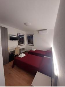 Romans di VarmoにあるLocanda Rossaのベッド2台、デスクが備わる小さな客室です。