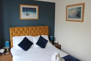 um quarto com uma cama branca e paredes azuis em Oliver Wests Beautiful 1 Bedroom Retreat em Scarborough