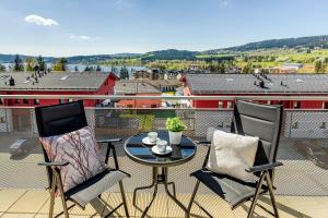 a patio with two chairs and a table on a balcony at KORZO Family in Lipno nad Vltavou