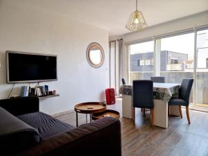 een woonkamer met een bank en een tafel bij T3 Paisible très proche plage in Canet-en-Roussillon