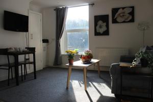 a living room with a table with flowers on it at Oliver Wests Beautiful 1 Bedroom Retreat in Scarborough