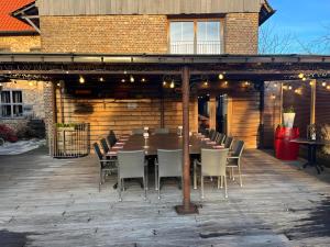 Une grande table et des chaises en bois sont disponibles sur la terrasse. dans l'établissement Herberg De Zwaan, à Saint-Trond