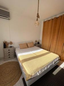 a bedroom with a large bed with a yellow blanket at CASA ROSA COSY PINK GUEST HOUSE in Torrão