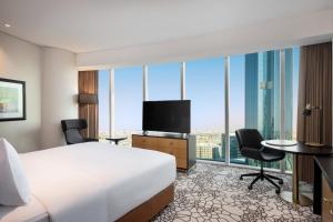 a hotel room with a bed and a flat screen tv at Hilton Riyadh Olaya in Riyadh