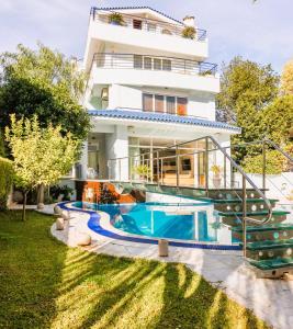 a villa with a swimming pool in front of a house at Villa Stefani with Private Pool in Athens